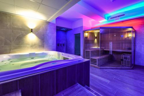 佩斯基耶拉德加达里乌斯酒店的大型浴室设有紫色照明浴缸