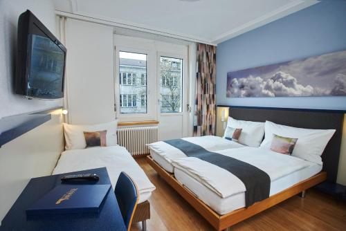 苏黎世苏黎世布里斯托尔酒店的一间酒店客房,设有两张床和电视