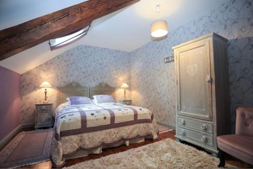 TalizatLe Château de Vernières的一间卧室配有一张大床和一把椅子
