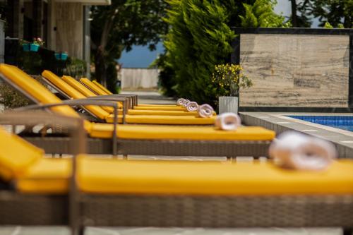 科布列季Chveni Ezo Boutique Hotel的游泳池旁的一排黄色椅子
