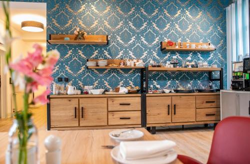 艾森纳赫安娜别墅布汀奎酒店的厨房配有木制橱柜和蓝色的墙壁