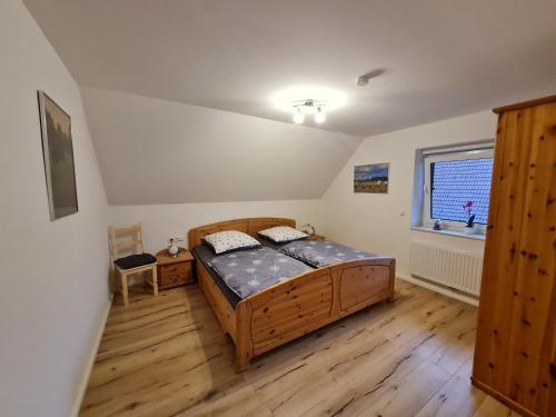 HemmoorFerienhaus Taucherperle的一间卧室设有一张木床和一个窗户。