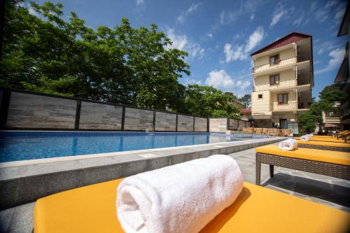 科布列季Hotel Chveni Ezo的游泳池旁的黄色桌子和毛巾
