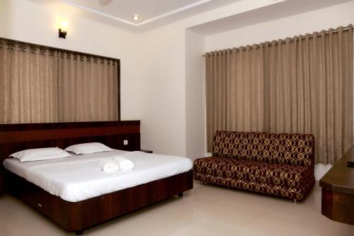 舍地Hotel Sai Ramanand的一间卧室配有一张床和一把椅子