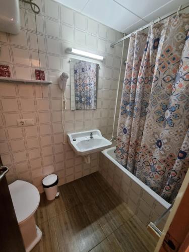罗列特海岸切尔沃潘欣旅馆的一间带水槽和淋浴帘的浴室