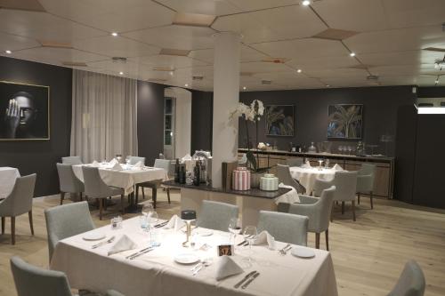 伯尼安Boutique Hôtel de l'Ecu Vaudois的餐厅配有桌椅和白色桌布