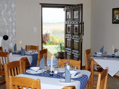 丹地Mountain View Guest House的一间设有两张桌子和窗户的用餐室