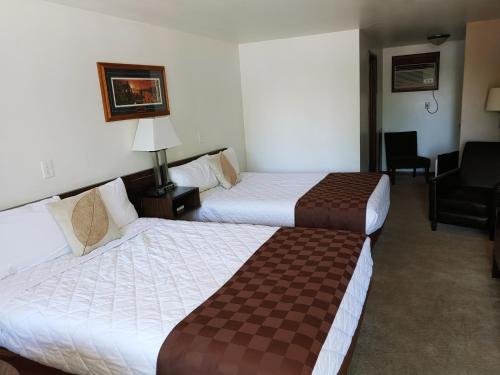 Iron RiverLakeshore Motel Ice Lake的酒店客房,配有两张床和椅子