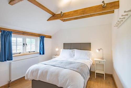 SandhurstMotor House Loft by Bloom Stays的一间卧室配有一张带蓝色窗帘的大床
