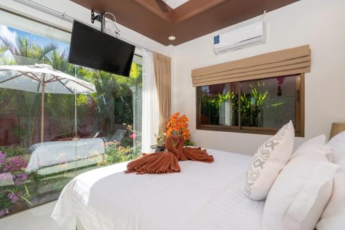 班巴克洛Boutique Resort Private Pool Villa - SHA Extra Plus的卧室设有白色的床和大窗户