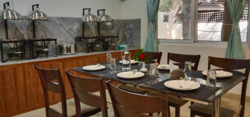 黎明之村GG Resorts的用餐室配有桌椅和桌子