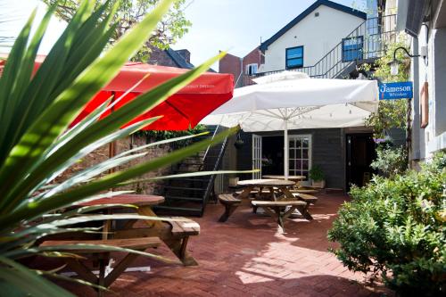 瓦伊河畔罗斯王首酒店的庭院设有长椅和遮阳伞及桌子。