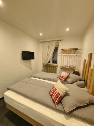 朗巴克Gîte le petit bûcheron的一间卧室设有两张床,墙上配有电视。