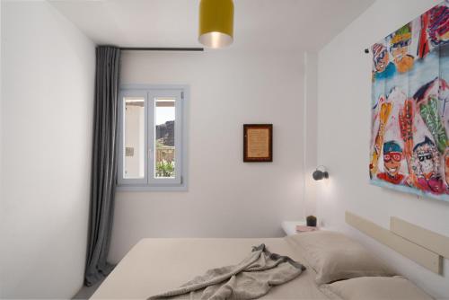 阿克罗蒂里Le Grand Blue Villa的白色的卧室设有床和窗户