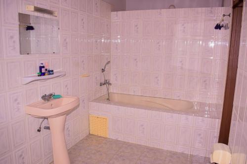 科托努ROMO house的浴室配有盥洗盆和浴缸。