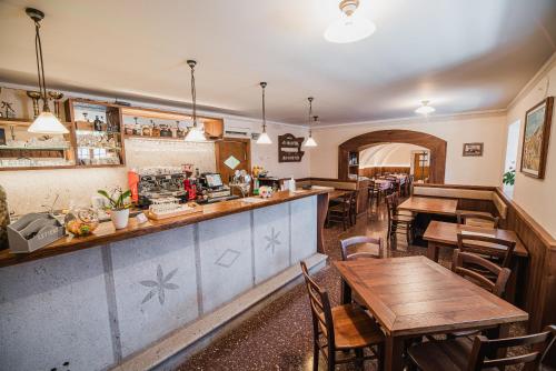 利皮卡Guesthouse Muha的一间带木桌椅的餐厅和一间酒吧