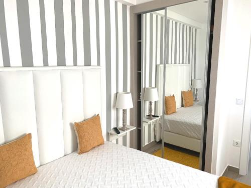 纳扎雷Duarte Houses - Casa T1 N - com vista mar的一间卧室配有一张床和一面大镜子