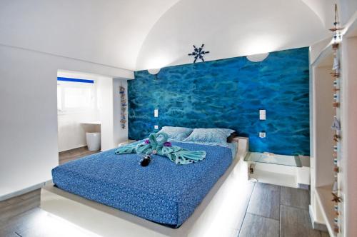 卡马利蓝色梦幻圣托里尼公寓的一间卧室设有蓝色墙和一张床