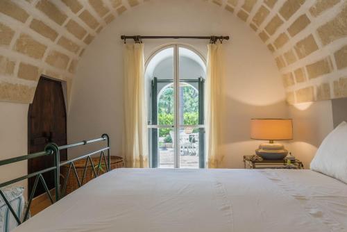 弗兰卡维拉丰塔纳Fontana Villa Resort的一间卧室设有一张床和一个大窗户