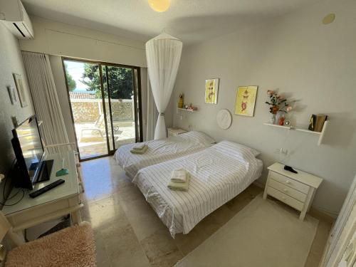 拉海瑞德拉Montepino 48的一间卧室配有一张床、一台电视和一个窗口