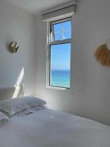 圣艾夫斯Harbour View House的一间卧室设有一张床和一个海景窗户
