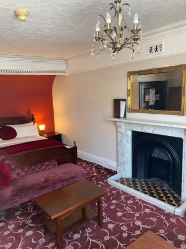 布里奇沃特The Tudor Hotel的酒店客房配有一张床和一个壁炉。
