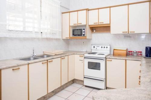 马盖特Seabrook 211 Margate RSA的厨房配有白色橱柜和白色炉灶烤箱。