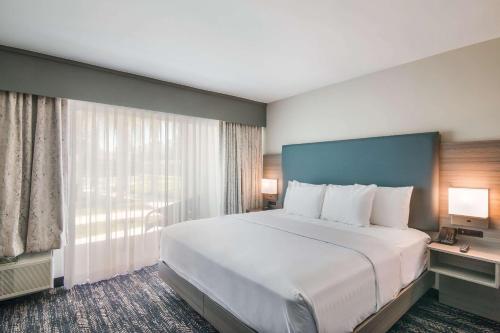 贝克斯菲尔德Hourglass Hotel, Ascend Hotel Collection的一张位于酒店客房的大床,设有大窗户