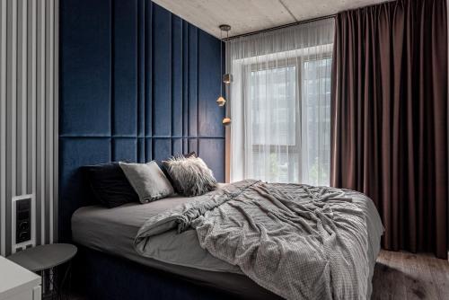 维尔纽斯Urban center apartment的一间拥有蓝色墙壁的卧室、一张床和窗户