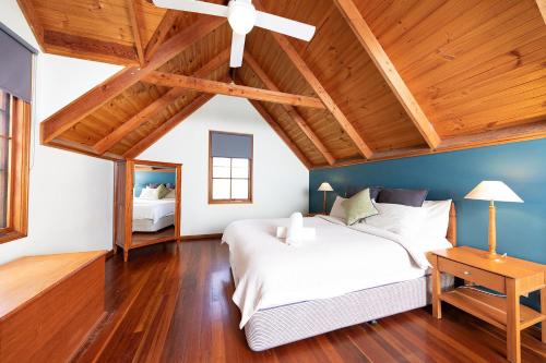 CobarkHidden Haven Barrington Tops的卧室设有白色的床和木制天花板。