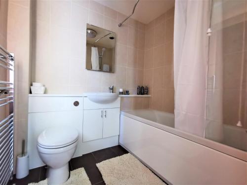 LlanfyrnachWellstone Cottages - Honeysuckle的浴室配有卫生间、浴缸和水槽。