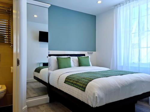 伦敦146 STUDIOS Regent's Park的一间卧室配有一张带绿色枕头的大床