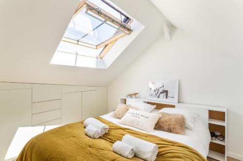 雷恩Maison Sévigné - Le calme du Thabor et la proximité du centre ville的一间卧室配有一张带天窗的大床