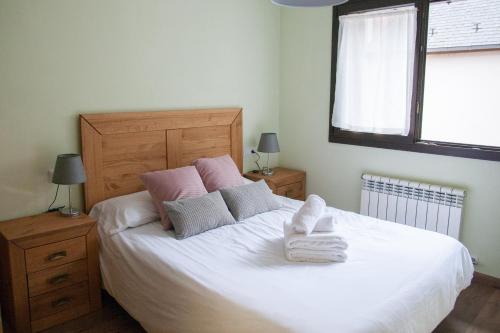 莱斯Apartamento Toran的卧室配有带毛巾的大型白色床