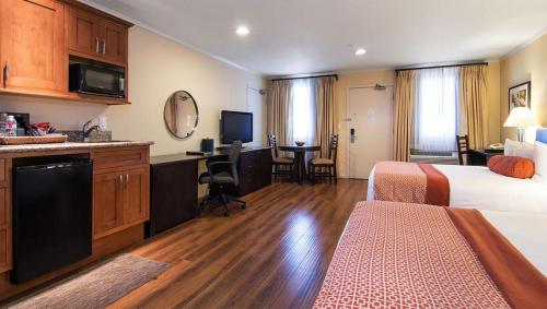 帕罗奥多The Zen Hotel Palo Alto的酒店客房配有一张床、一张书桌和一间厨房。