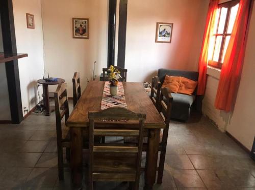 波特雷里约斯Casa Montaña Valle del Sol的一间带木桌和椅子的用餐室