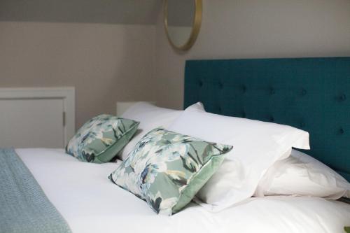 约克The Loft, Bootham House - luxury city centre apartment with parking space的一张带白色枕头和蓝色床头板的床