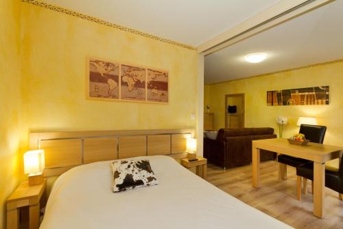 伊索拉2000Résidence mmv Les terrasses d'Isola的一间卧室配有一张床、一张桌子和一张沙发