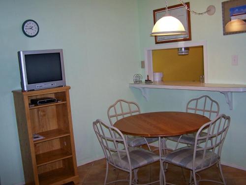 阿兰瑟斯港Mustang Bungalow 4MI的一间带桌子和电视的用餐室
