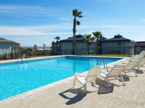阿兰瑟斯港Vista del Mar 505BH的一个带白色椅子和棕榈树的游泳池