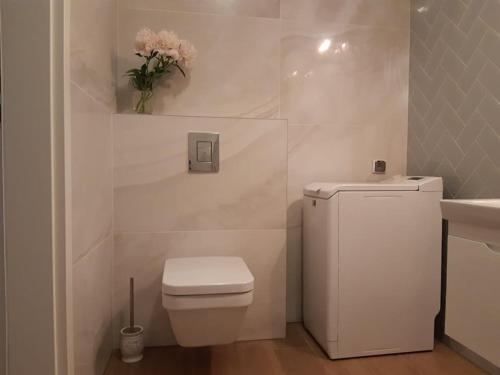 科沃布热格Mazowiecka Park的白色的浴室设有卫生间和花瓶