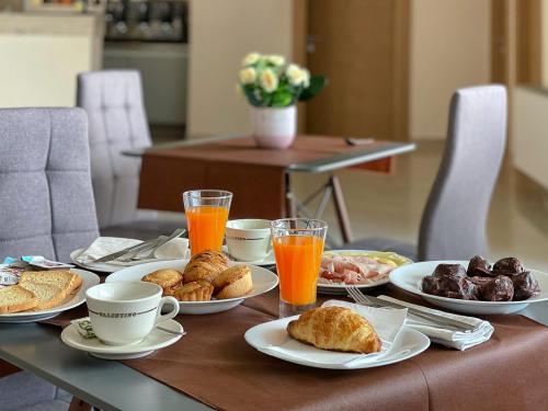 卡尔皮尼亚诺萨伦蒂诺Karpignàna Hotel的餐桌,盘子上放着食物和橙汁