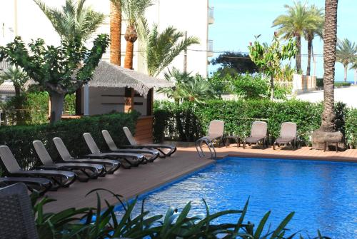 甘迪亚罗斯罗布雷斯酒店的毗邻度假酒店的带躺椅的游泳池
