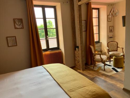 拉佩蒂特皮耶尔Les Chambres - Au Grès du marché的一间卧室设有一张床、一个窗口和一把椅子