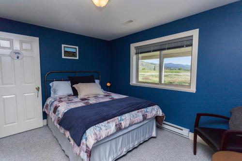 坎卢普斯奥弗兰德住宿加早餐旅馆的蓝色的卧室设有床和窗户