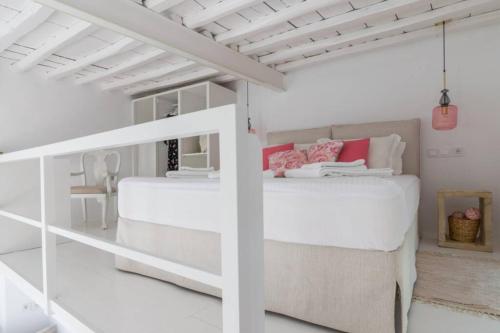 基莫洛斯岛Stella's House的一间白色卧室,配有两张床和楼梯