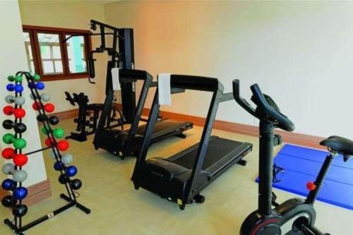 多明戈斯马丁斯Condomínio Vista Azul -CASA DOS CARDOSO的健身房设有数台跑步机和健身自行车