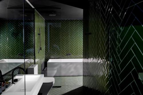 霍巴特Moss Hotel的绿色浴室设有浴缸、水槽和浴缸