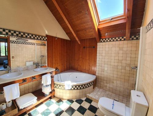 洛斯休特斯提瑞斯德莫亚酒店的带浴缸、两个盥洗盆和卫生间的浴室