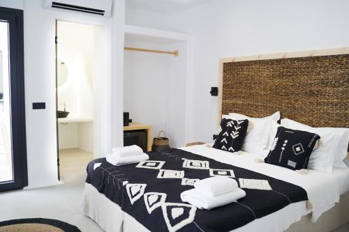 卡马利国王套房酒店的一间卧室配有一张大床,提供黑白枕头